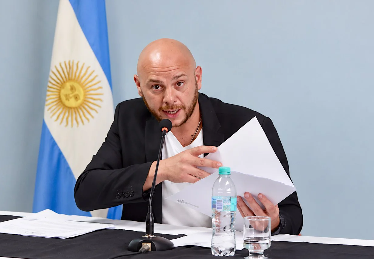 Darío Menna hablando con papeles al micrófono